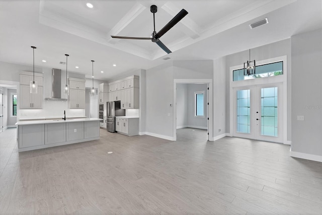 14089 Wenzel Ave, Port Charlotte, FL 33981 - kitchen with wall chimney exhaust hood, freestanding refrigerator, light countertops, a ceiling fan, and light wood-style floors