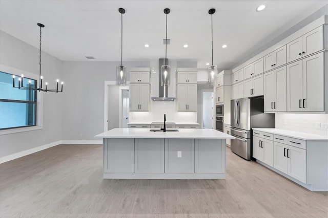 14089 Wenzel Ave, Port Charlotte, FL 33981 - kitchen with stainless steel appliances, wall chimney range hood, light countertops, light wood finished floors, and recessed lighting