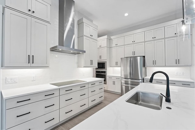 14089 Wenzel Ave, Port Charlotte, FL 33981 - kitchen featuring wall chimney exhaust hood, stainless steel appliances, backsplash, light wood-type flooring, and recessed lighting