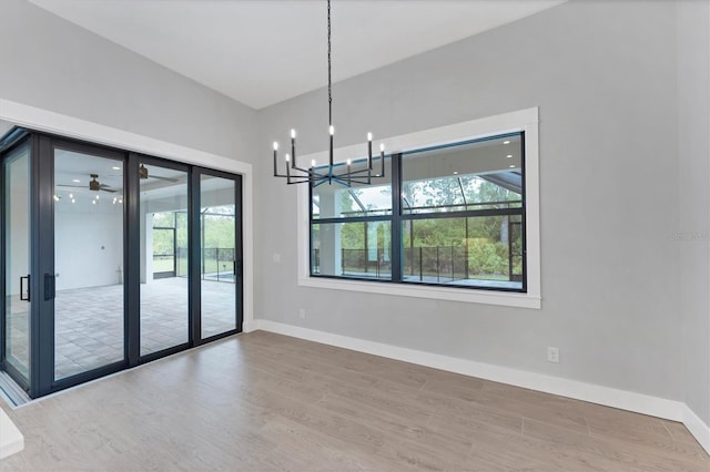 14089 Wenzel Ave, Port Charlotte, FL 33981 - unfurnished room featuring wood finished floors, healthy amount of natural light, and a chandelier
