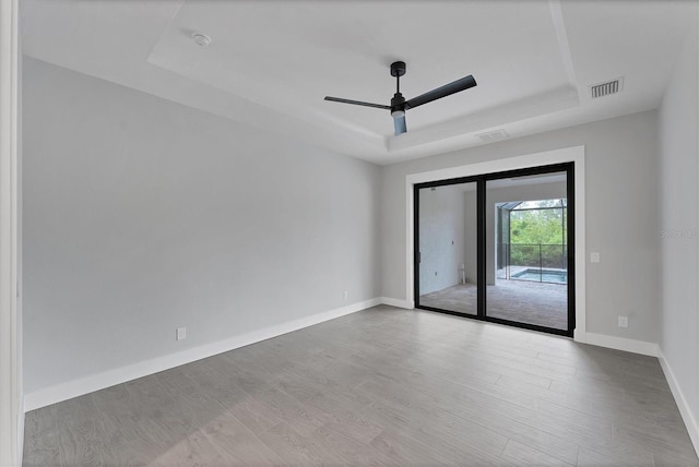 14089 Wenzel Ave, Port Charlotte, FL 33981 - unfurnished room featuring a tray ceiling, a ceiling fan, wood finished floors, and a smoke detector