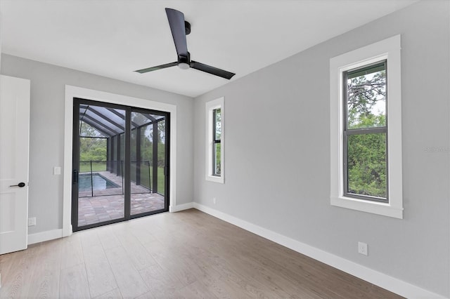 14089 Wenzel Ave, Port Charlotte, FL 33981 - unfurnished room with plenty of natural light, wood finished floors, and a ceiling fan