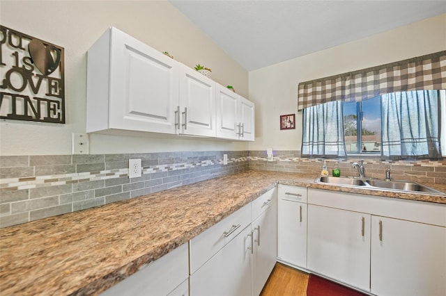 7580 Hanchey St, North Port, FL 34287 - kitchen featuring tasteful backsplash, white cabinetry, light countertops, and light wood-style flooring