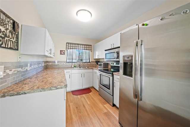 7580 Hanchey St, North Port, FL 34287 - kitchen featuring appliances with stainless steel finishes, light wood-type flooring, tasteful backsplash, white cabinetry, and light countertops