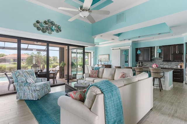 1131 Rotonda Cir, Rotonda West, FL 33947 - living room featuring ornamental molding, light wood finished floors, a ceiling fan, and a towering ceiling