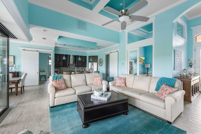 1131 Rotonda Cir, Rotonda West, FL 33947 - living room featuring a barn door, ornamental molding, light wood finished floors, and arched walkways