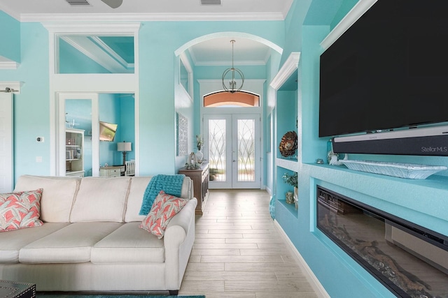 1131 Rotonda Cir, Rotonda West, FL 33947 - living room with crown molding, french doors, arched walkways, and wood finished floors