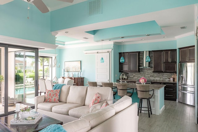 1131 Rotonda Cir, Rotonda West, FL 33947 - living room with a raised ceiling, ornamental molding, ceiling fan, and light wood-style flooring