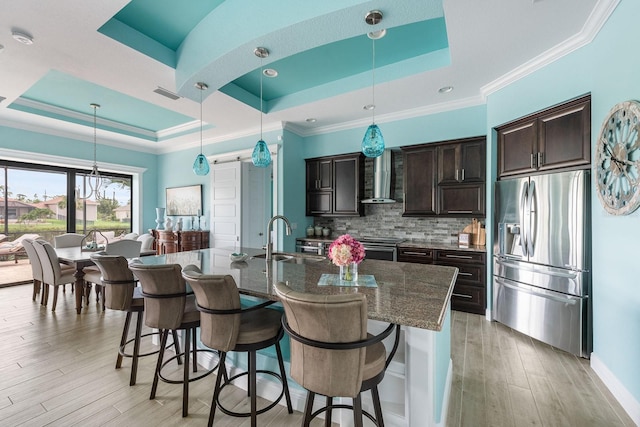 1131 Rotonda Cir, Rotonda West, FL 33947 - kitchen with stainless steel refrigerator with ice dispenser, a tray ceiling, a kitchen breakfast bar, wall chimney exhaust hood, and crown molding