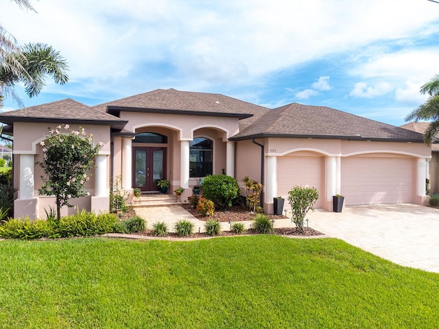 1131 Rotonda Cir, Rotonda West, FL 33947 - view of front facade with french doors, stucco siding, a front yard, an attached garage, and driveway