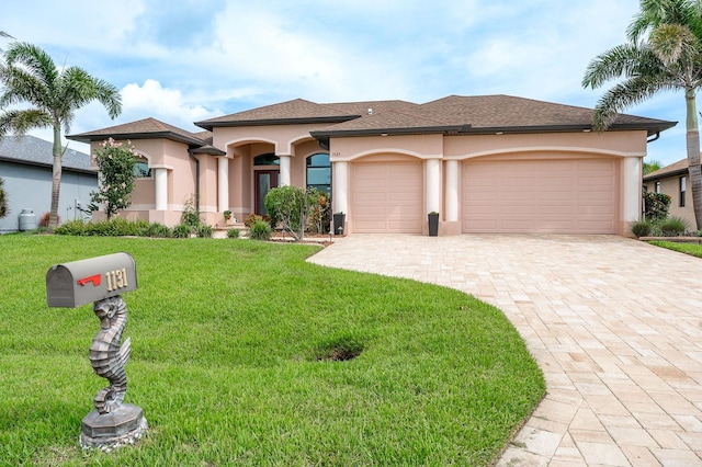 1131 Rotonda Cir, Rotonda West, FL 33947 - view of front of home featuring stucco siding, decorative driveway, an attached garage, and a front lawn