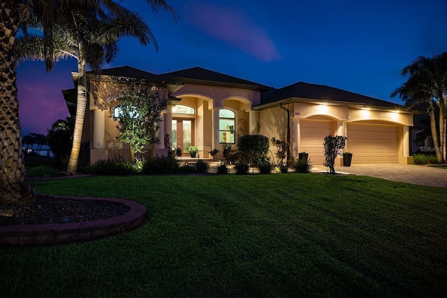 1131 Rotonda Cir, Rotonda West, FL 33947 - mediterranean / spanish house with an attached garage, stucco siding, french doors, a yard, and driveway