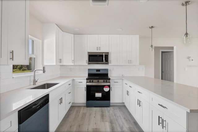 234 Boundary Blvd Unit 3, Rotonda West, FL 33947 - kitchen with appliances with stainless steel finishes, a peninsula, tasteful backsplash, and white cabinetry