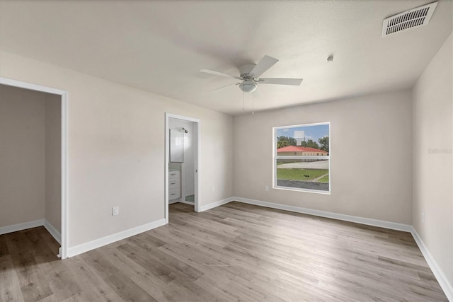 234 Boundary Blvd Unit 3, Rotonda West, FL 33947 - unfurnished bedroom featuring wood finished floors, ceiling fan, and ensuite bathroom