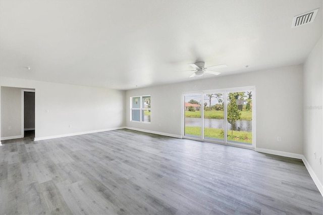 234 Boundary Blvd Unit 3, Rotonda West, FL 33947 - unfurnished living room featuring ceiling fan, wood finished floors, and a water view