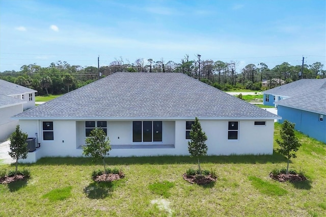 234 Boundary Blvd Unit 3, Rotonda West, FL 33947 - rear view of property with stucco siding, roof with shingles, and a lawn