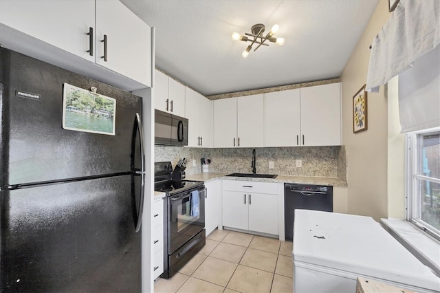 7590 Lyncrest St, North Port, FL 34287 - kitchen with black appliances, backsplash, white cabinets, and light tile patterned floors