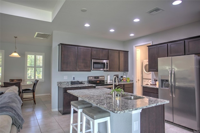 22156 Deborah Ave, Port Charlotte, FL 33954 - kitchen featuring stainless steel appliances, dark brown cabinetry, light tile patterned floors, recessed lighting, and light stone counters