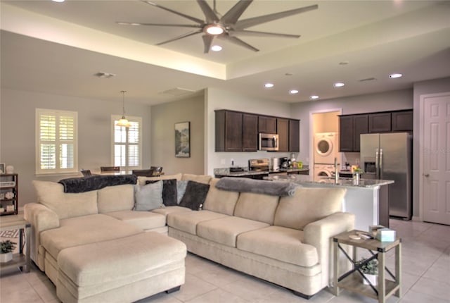 22156 Deborah Ave, Port Charlotte, FL 33954 - living room featuring stacked washer / dryer, ceiling fan, light tile patterned floors, recessed lighting, and a tray ceiling