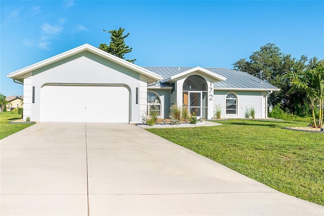 172 Mariner Ln, Rotonda West, FL 33947 - ranch-style home with an attached garage, a standing seam roof, stucco siding, a front lawn, and concrete driveway