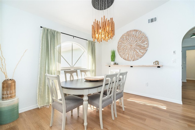 172 Mariner Ln, Rotonda West, FL 33947 - dining area featuring arched walkways, wood finished floors, a chandelier, and vaulted ceiling
