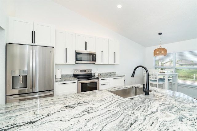 172 Mariner Ln, Rotonda West, FL 33947 - kitchen featuring stainless steel appliances, lofted ceiling, light stone countertops, white cabinetry, and pendant lighting