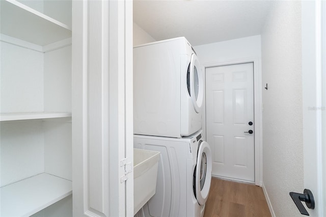 172 Mariner Ln, Rotonda West, FL 33947 - laundry room featuring stacked washing machine and dryer and light wood-type flooring