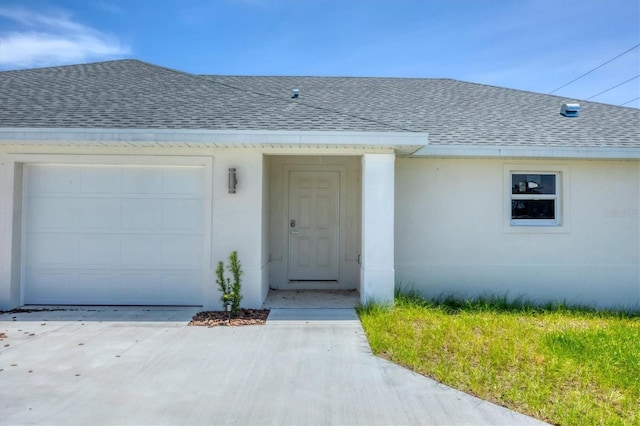 236 Boundary Blvd, Rotonda West, FL 33947 - property entrance with roof with shingles, an attached garage, stucco siding, and concrete driveway