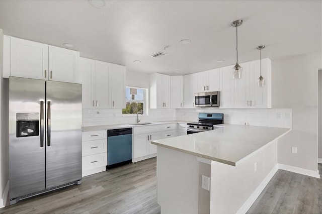 236 Boundary Blvd, Rotonda West, FL 33947 - kitchen featuring stainless steel appliances, light wood-style floors, a peninsula, white cabinetry, and recessed lighting