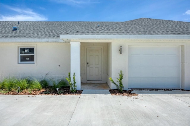 236 Boundary Blvd, Rotonda West, FL 33947 - doorway to property featuring roof with shingles, a garage, and stucco siding