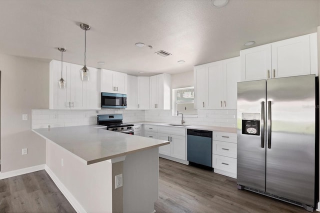 236 Boundary Blvd, Rotonda West, FL 33947 - kitchen featuring appliances with stainless steel finishes, a peninsula, white cabinets, dark wood-type flooring, and recessed lighting