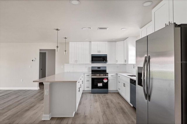 236 Boundary Blvd, Rotonda West, FL 33947 - kitchen with appliances with stainless steel finishes, a peninsula, tasteful backsplash, and light wood finished floors
