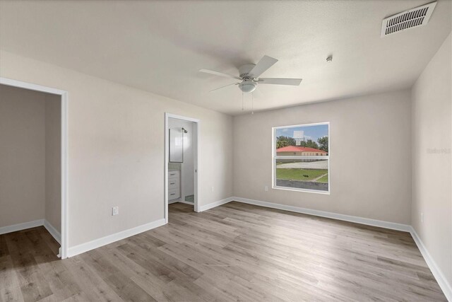 236 Boundary Blvd, Rotonda West, FL 33947 - unfurnished bedroom featuring wood finished floors, ceiling fan, and ensuite bathroom