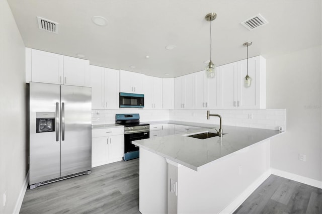 236 Boundary Blvd, Rotonda West, FL 33947 - kitchen with appliances with stainless steel finishes, a peninsula, light wood-type flooring, light stone countertops, and tasteful backsplash