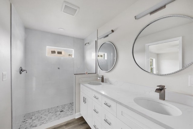 236 Boundary Blvd, Rotonda West, FL 33947 - full bathroom with double vanity, tiled shower, and wood finished floors