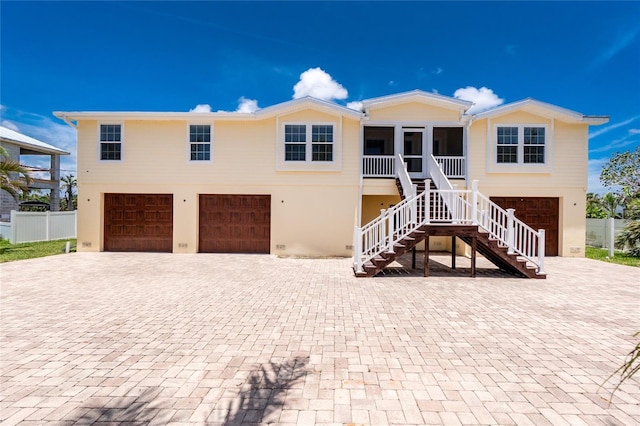 9150 Pine Cove Dr, Englewood, FL 34224 - view of front facade with a garage, decorative driveway, and stairway