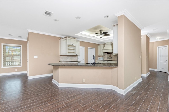 9150 Pine Cove Dr, Englewood, FL 34224 - kitchen with ornamental molding, decorative backsplash, dark wood-style flooring, cream cabinetry, and a ceiling fan