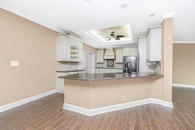 9150 Pine Cove Dr, Englewood, FL 34224 - kitchen with premium range hood, stainless steel fridge, wood finished floors, ceiling fan, and crown molding