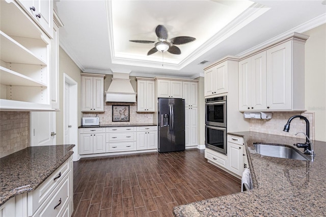 9150 Pine Cove Dr, Englewood, FL 34224 - kitchen with black refrigerator with ice dispenser, custom exhaust hood, a raised ceiling, stainless steel double oven, and ceiling fan