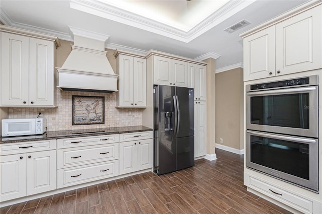 9150 Pine Cove Dr, Englewood, FL 34224 - kitchen featuring refrigerator with ice dispenser, double oven, white microwave, premium range hood, and ornamental molding