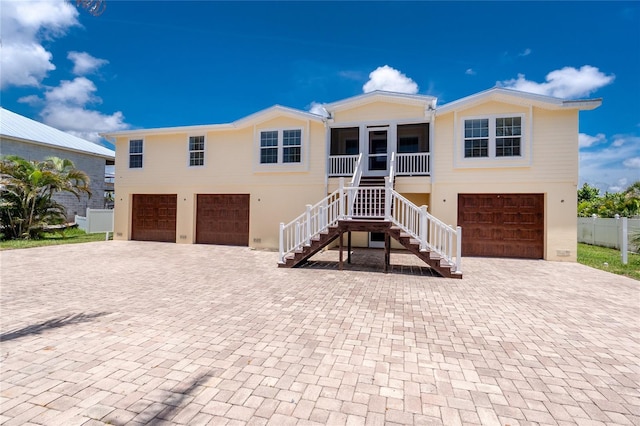 9150 Pine Cove Dr, Englewood, FL 34224 - view of front facade with an attached garage, stairs, and decorative driveway