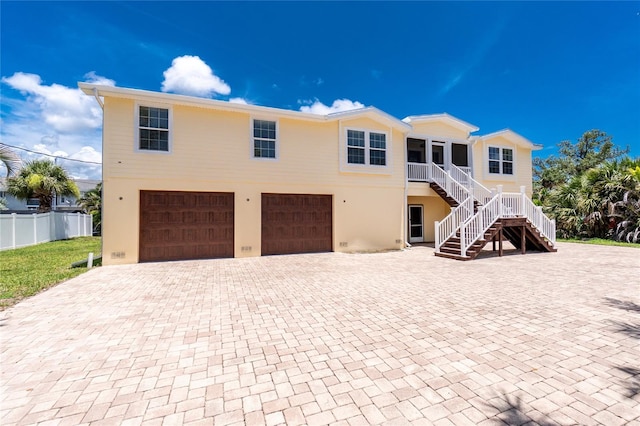 9150 Pine Cove Dr, Englewood, FL 34224 - view of front facade featuring an attached garage, stairs, decorative driveway, and stucco siding
