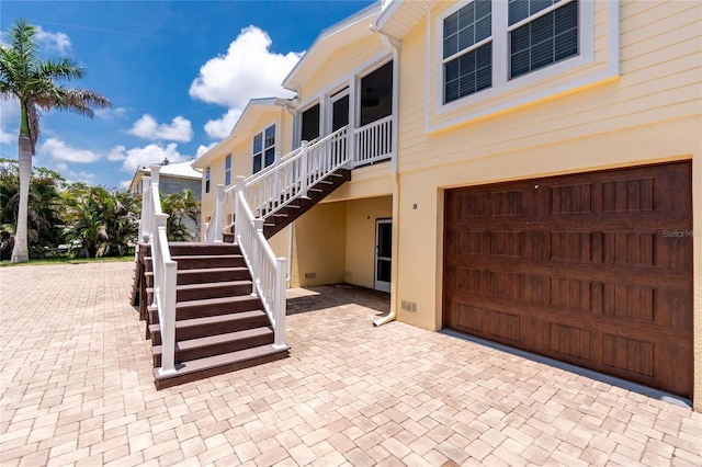 9150 Pine Cove Dr, Englewood, FL 34224 - view of property exterior featuring stairs, stucco siding, and an attached garage
