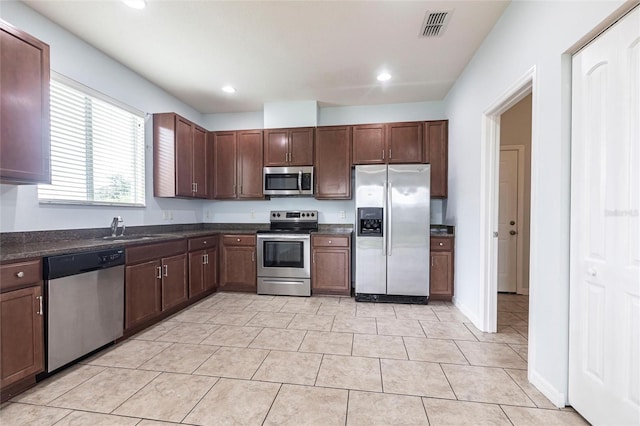 7318 61st St E, Palmetto, FL 34221 - kitchen featuring appliances with stainless steel finishes, dark countertops, recessed lighting, and light tile patterned floors