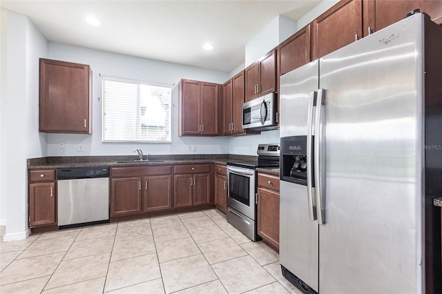 7318 61st St E, Palmetto, FL 34221 - kitchen with appliances with stainless steel finishes, dark countertops, light tile patterned floors, and recessed lighting