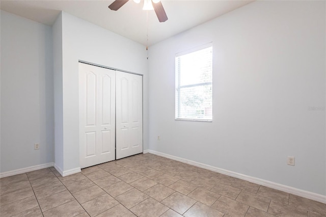 7318 61st St E, Palmetto, FL 34221 - unfurnished bedroom with a closet, light tile patterned floors, and a ceiling fan
