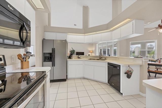 102 Marker Rd, Rotonda West, FL 33947 - kitchen with black appliances, a peninsula, a high ceiling, light countertops, and white cabinetry