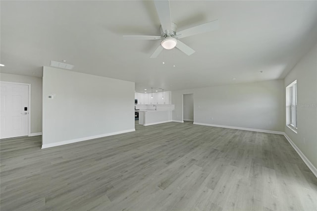 238 Boundary Blvd Unit 3, Rotonda West, FL 33947 - unfurnished living room featuring ceiling fan and light wood-type flooring