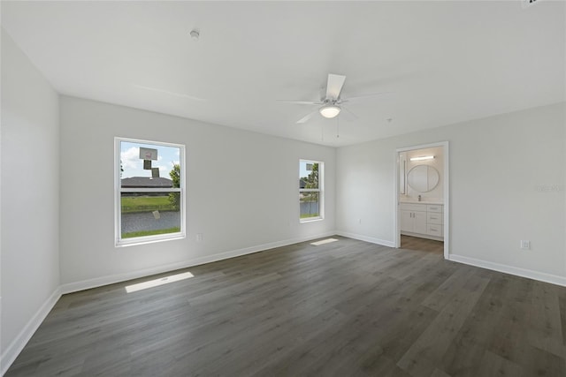 238 Boundary Blvd Unit 3, Rotonda West, FL 33947 - unfurnished bedroom with multiple windows, dark wood-type flooring, ensuite bath, and a ceiling fan