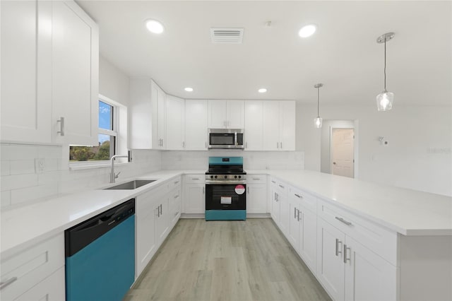 238 Boundary Blvd Unit 3, Rotonda West, FL 33947 - kitchen with stainless steel appliances, a peninsula, white cabinetry, tasteful backsplash, and light countertops